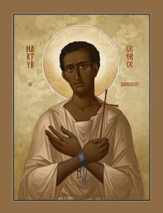 An icon of St. George holding a cross with his hands across his chest and prison cuffs on his wrists.